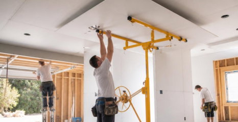 Photorealistic-new-residential-construction-drywall-installation-contractors-installing-drywall-on-interior-walls-and-ceilings-in-a-house-under-construction-visible-garage-and-addition-framing-in-the-background-careful-planning-quality-.jpg