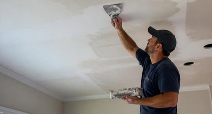 Photorealistic-ceiling-drywall-repair-in-a-home-interior-contractor-on-a-ladder-patching-cracks-holes-and-sagging-drywall-on-the-ceiling-blending-the-repair-to-match-the-existing-finish-realistic-renovation-scene-natural-lighting.jpg